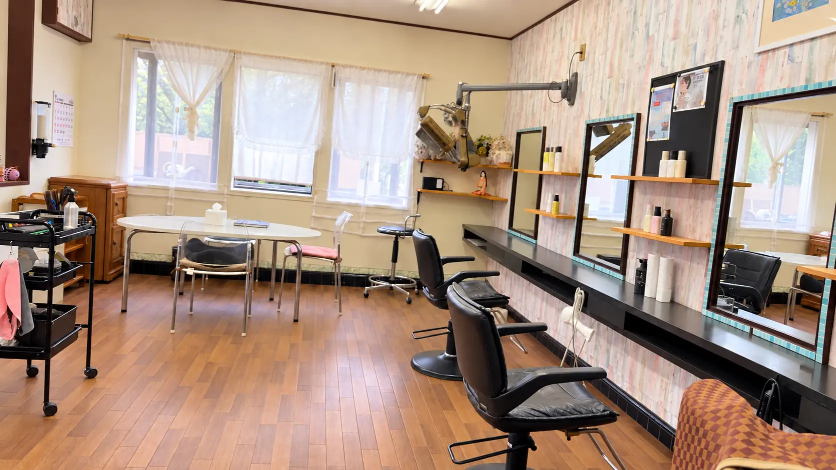 窓からの光が入る、木の床と黒い椅子の店内